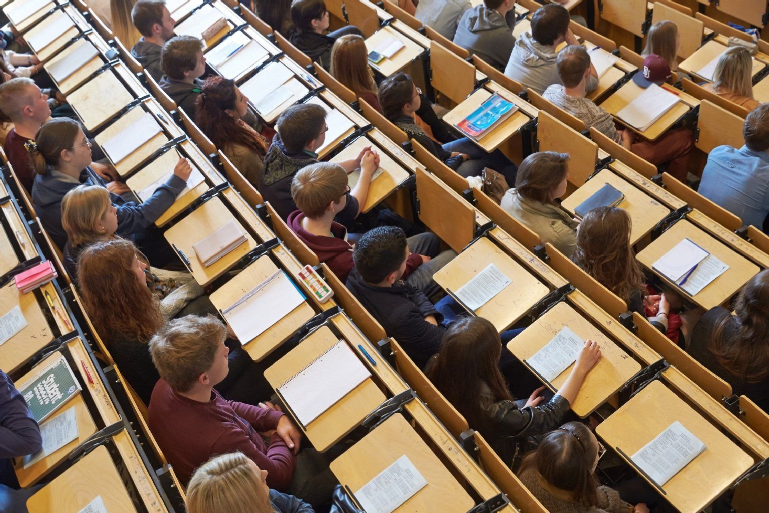 Studenten sitzen im großen Hörsaal einer Universität.