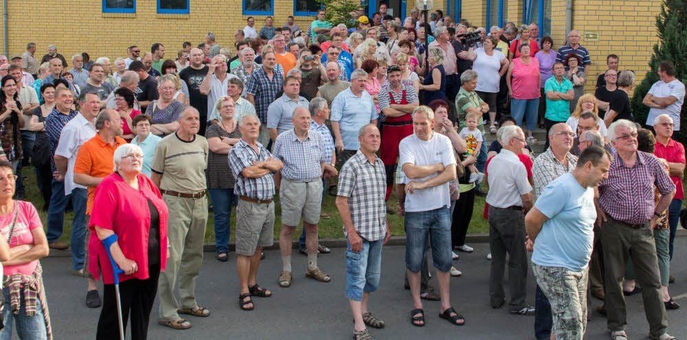 Die versammelten Bürger bekommen vor dem Haus des Abwasserzweckverbandes das Ende der Sitzung verkündet.