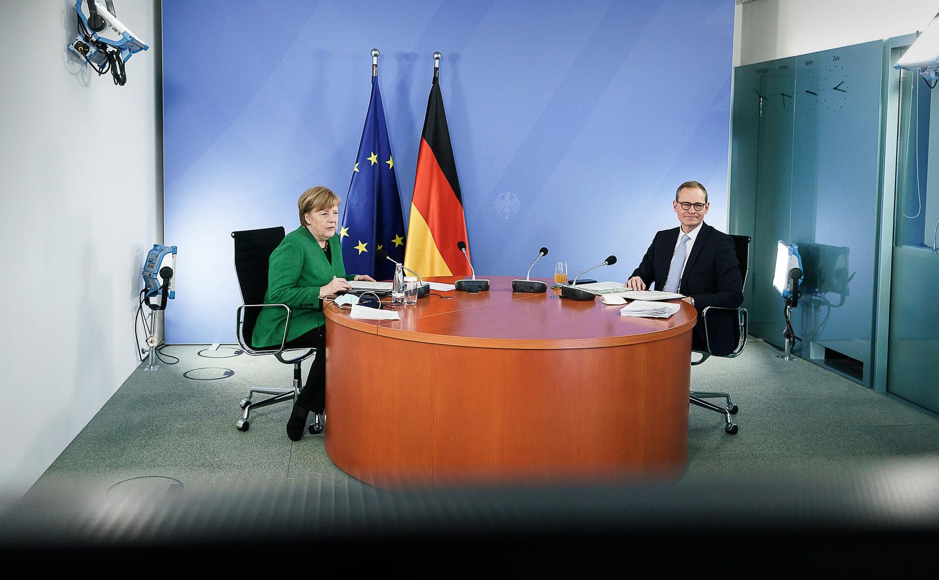 Bundeskanzlerin Angela Merkel (CDU) und Michael Müller (SPD), Regierender Bürgermeister von Berlin, sitzen während einer Videokonferenz mit den Ministerpräsidenten der Länder.