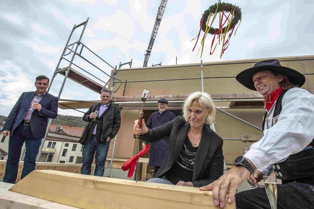 Geschäftsführerin Kirsten Föhse schlägt den symbolischen letzten Nagel in den Hotel-Rohbau ein.