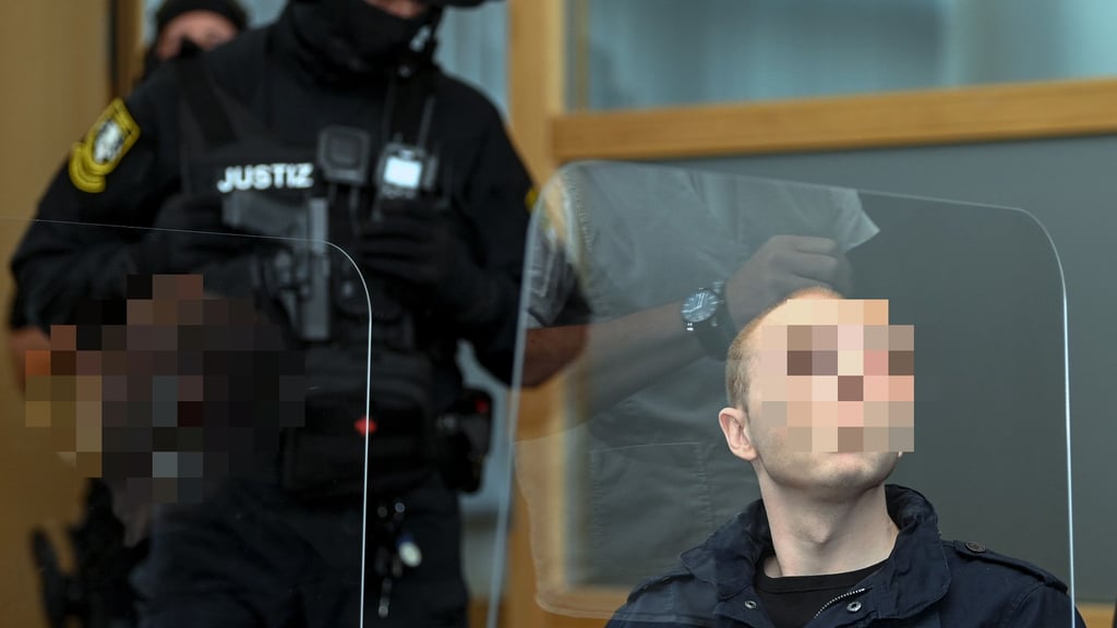 Der Angeklagte mit seinen Bewachern.