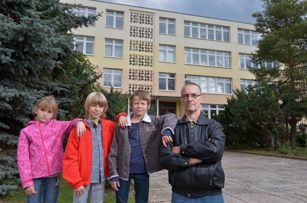 Nancy, Tom und Paul stehen mit ihrem Vater Fred Gregor vor der Görziger Grundschule.