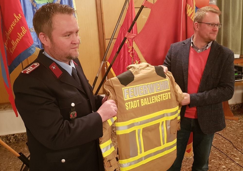 Die Feuerwehrleute aus Rieder haben neue Einsatzbekleidung bekommen. Ballenstedts Bürgermeister Michael Knoppik überreicht dem stellvertretenden Ortswehrleiter Carsten Beck (l.) eine der Jacken.