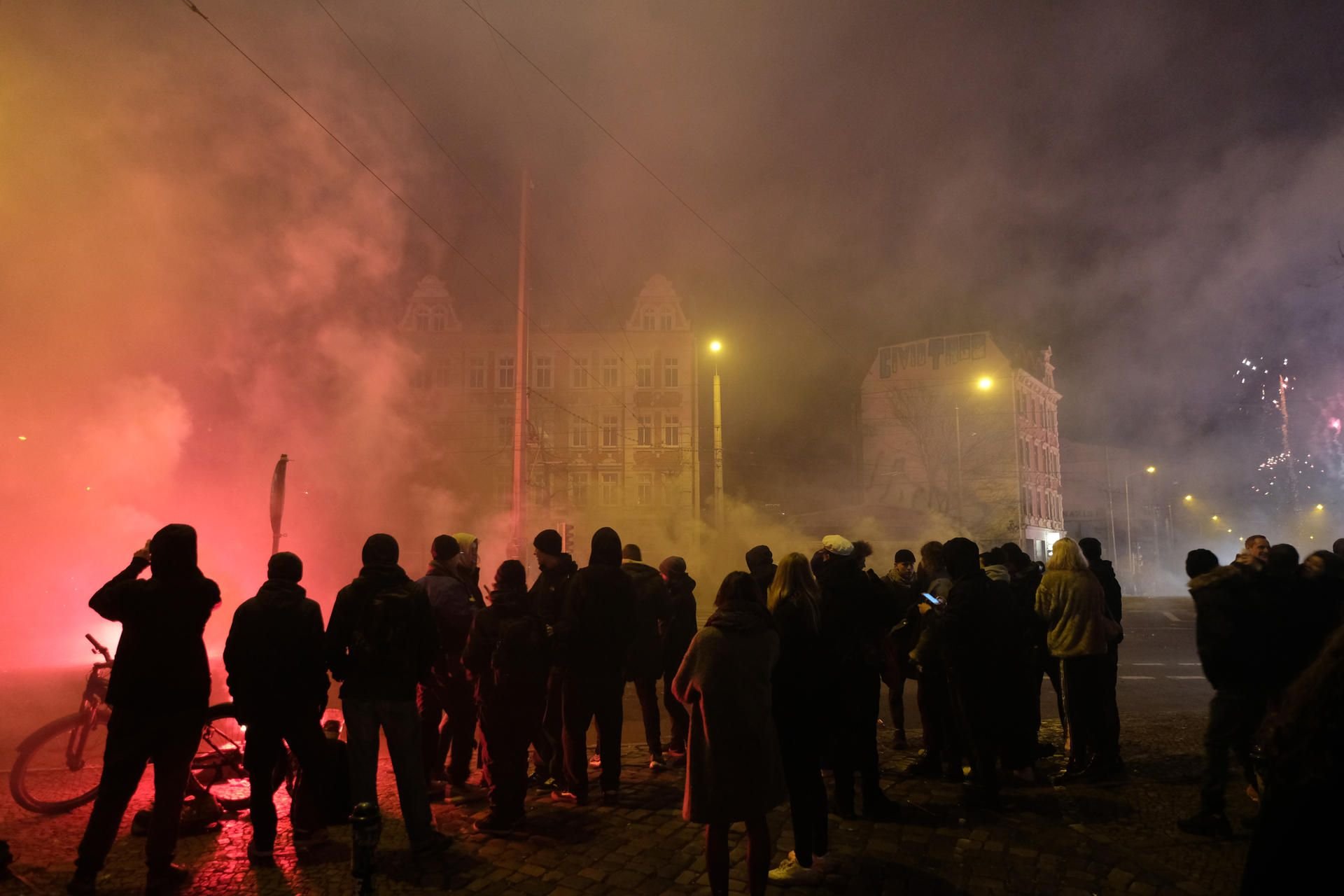 Passanten und Feiernde stehen am Silvesterabend am Connewitzer Kreuz.
