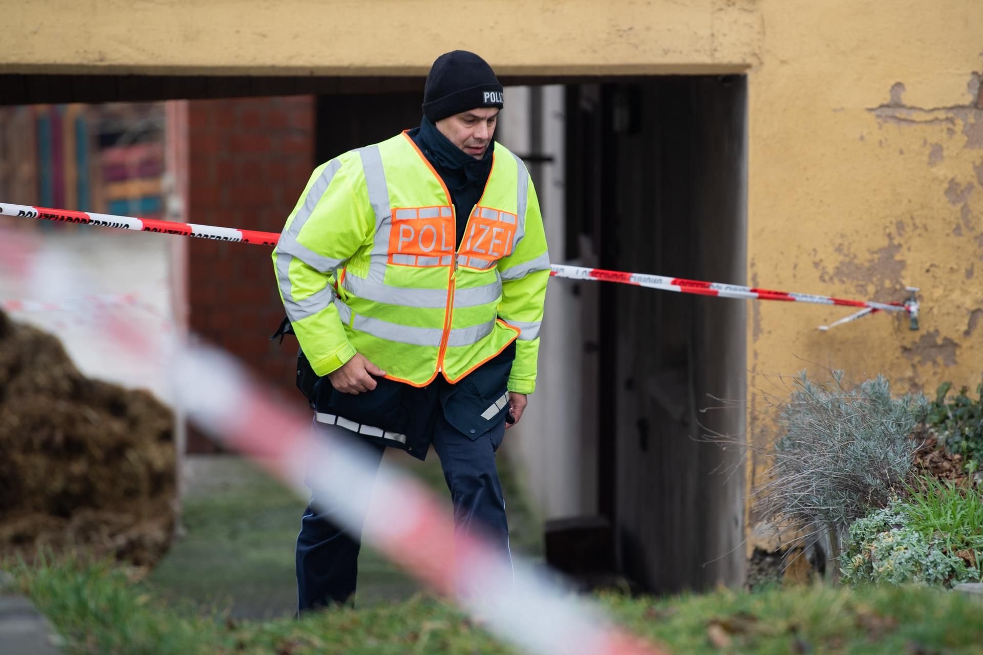Ein Polizist läuft am Tag nach den tödlichen Schüssen in Rot am See mit 6 Toten durch Absperrband der Polizei.