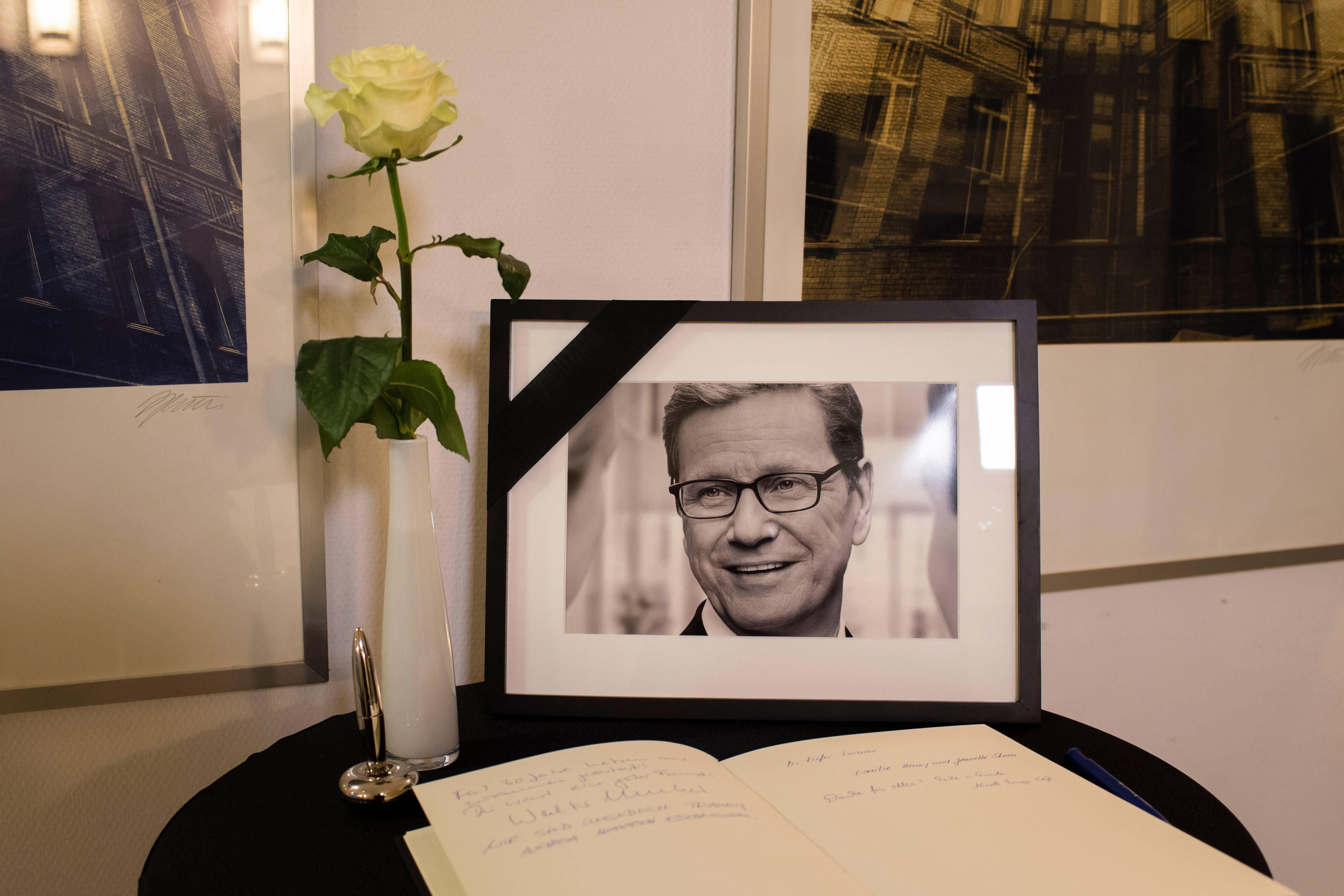 Ein Foto von Guido Westerwelle sTisch neben einem Kondolenzbuch im Eingangsbereich des Thomas-Dehler-Haus in Berlin