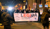 Teilnehmer einer Demonstration des fremdenfeindlichen Bündnisses Legida laufen am 09.01.2017 in Leipzig (Sachsen) eine Straße entlang.