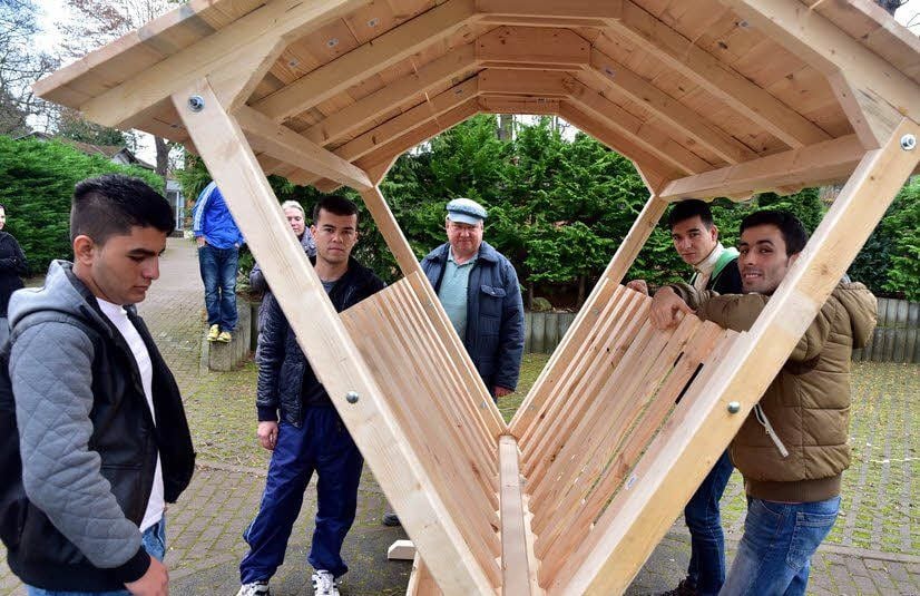 Die Flüchtlinge bestaunen die Krippe, die Bernd Kallies (5. von links) gebaut hat.