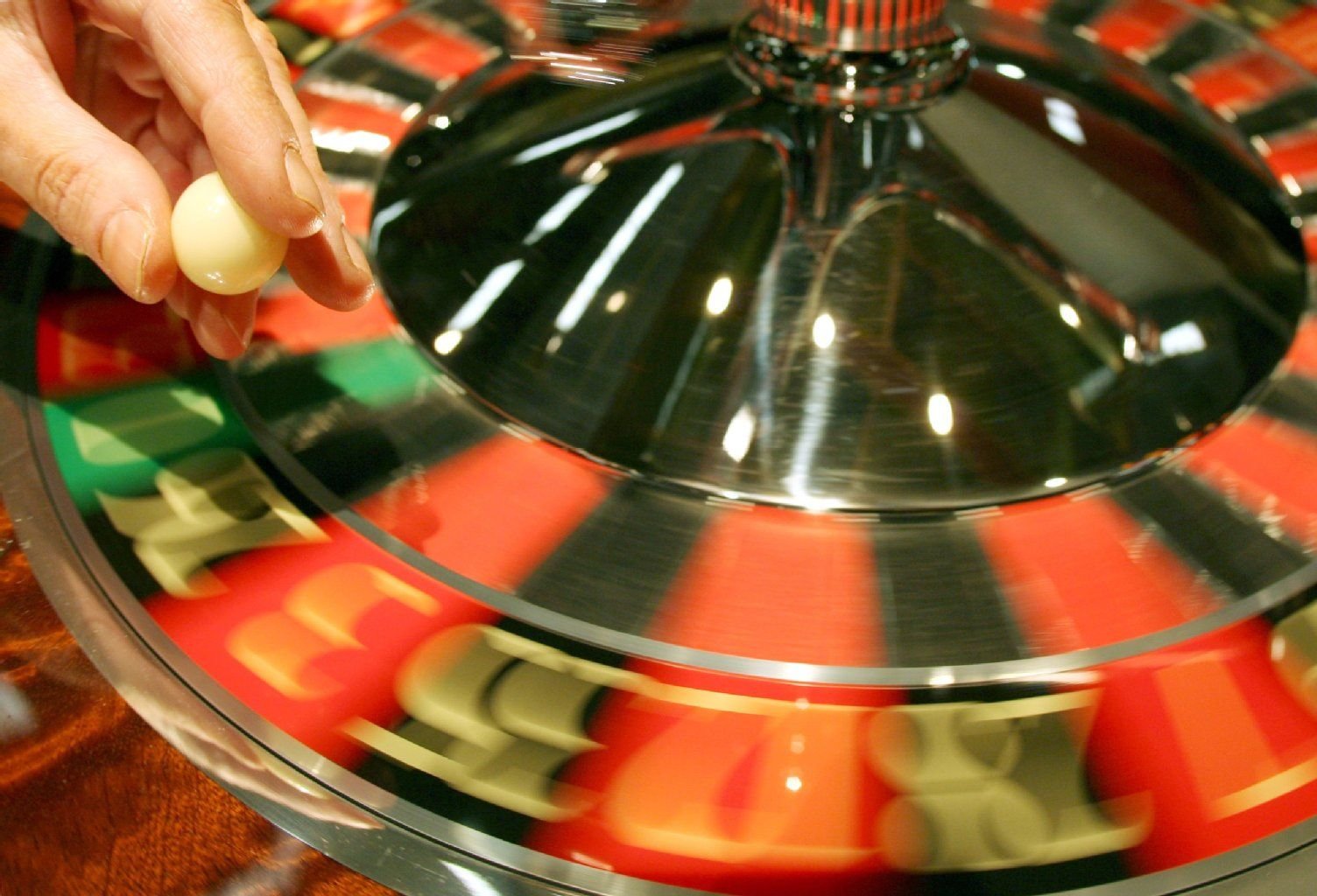 Ein Croupier wirft eine Roulette-Kugel in den sogenannten Kessel.