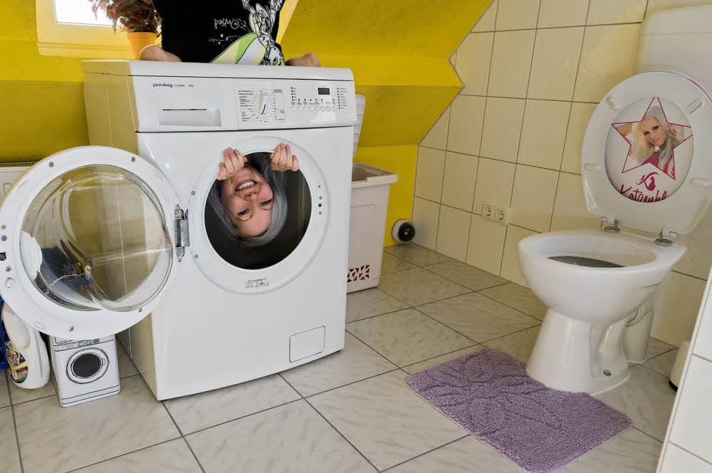 Besucherin Cindy Fitzner posiert in der Waschmaschine für den Fotografen.