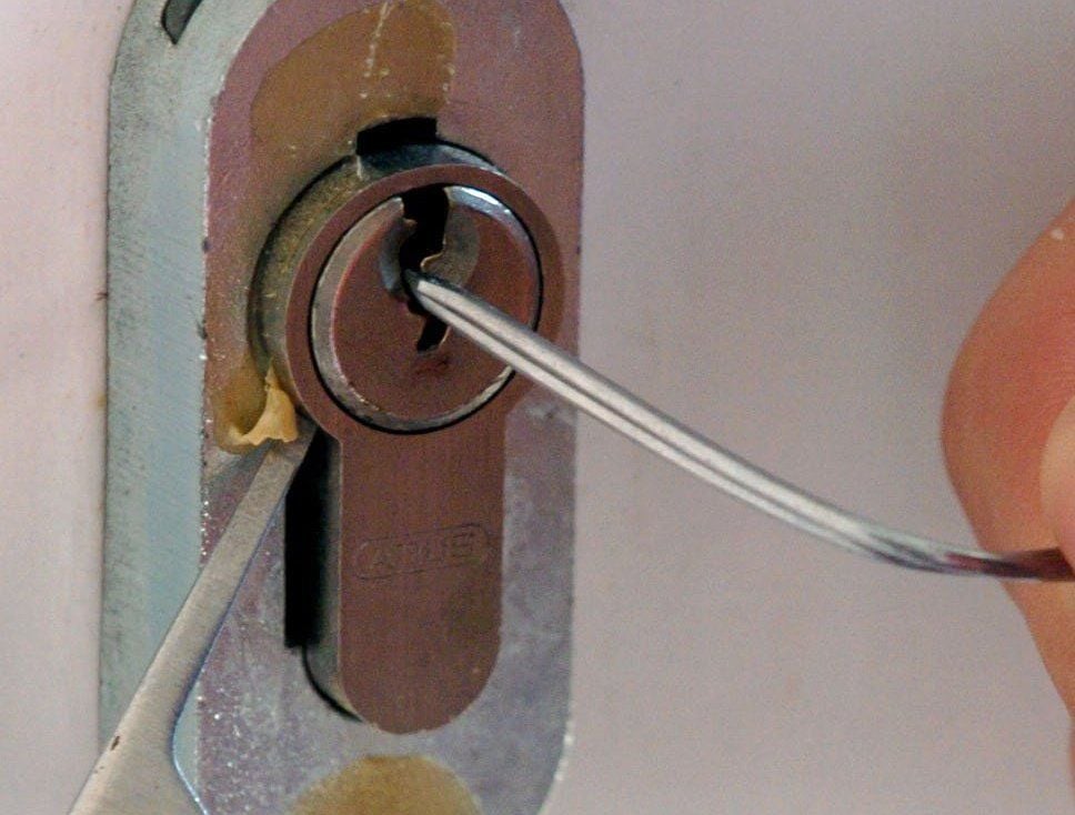 Einbruch: Ein Türschloss wird mit einem Draht und einem Multifunktionswerkzeug geöffnet.