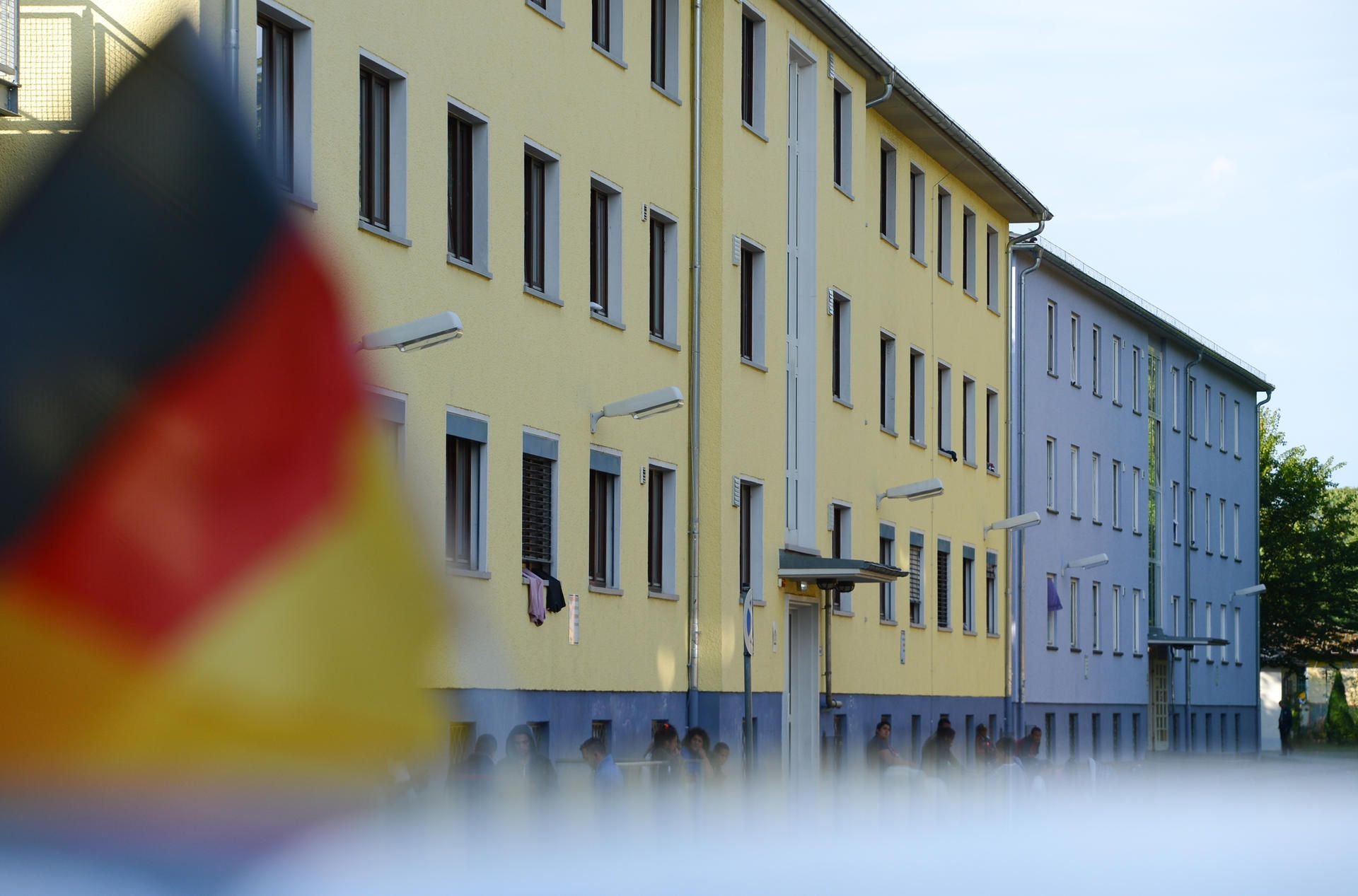 Eine Deutschlandfahne weht auf dem Gelände der hessischen Erstaufnahmeeinrichtung für Flüchtlinge in Gießen (Hessen) auf einem Autodach.