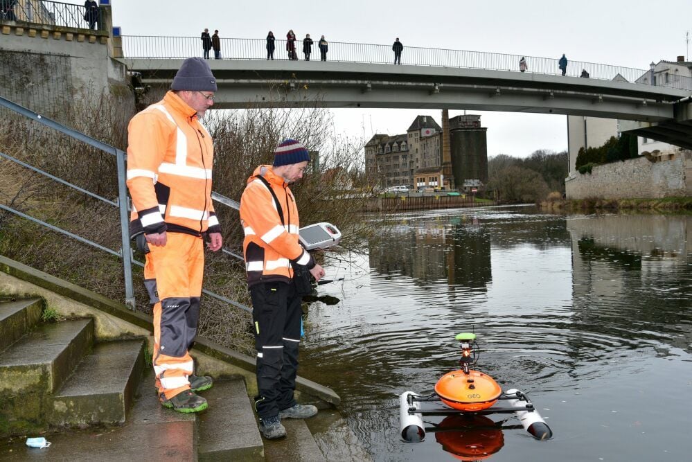 Jörg Bernhardt (links) und Stefan Meyer lassen nahe der Schleuse in Bernburg den „Sonobot“ auf der Saale zu Wasser. Das Gerät vermisst den Untergrund.