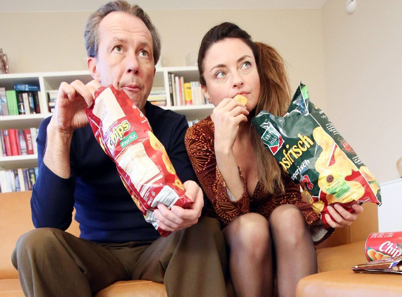 Mit Chips auf dem Sofa. Statt gemeinsam zu versacken, sollten Paare sich lieber zum Teamsport aufraffen.