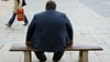 Ein stark übergewichtiger Mann sitzt auf einer Bank. Bundesweit beträgt der Unterschied der Lebenserwartung zwischen Männern und Frauen fünf Jahre.
