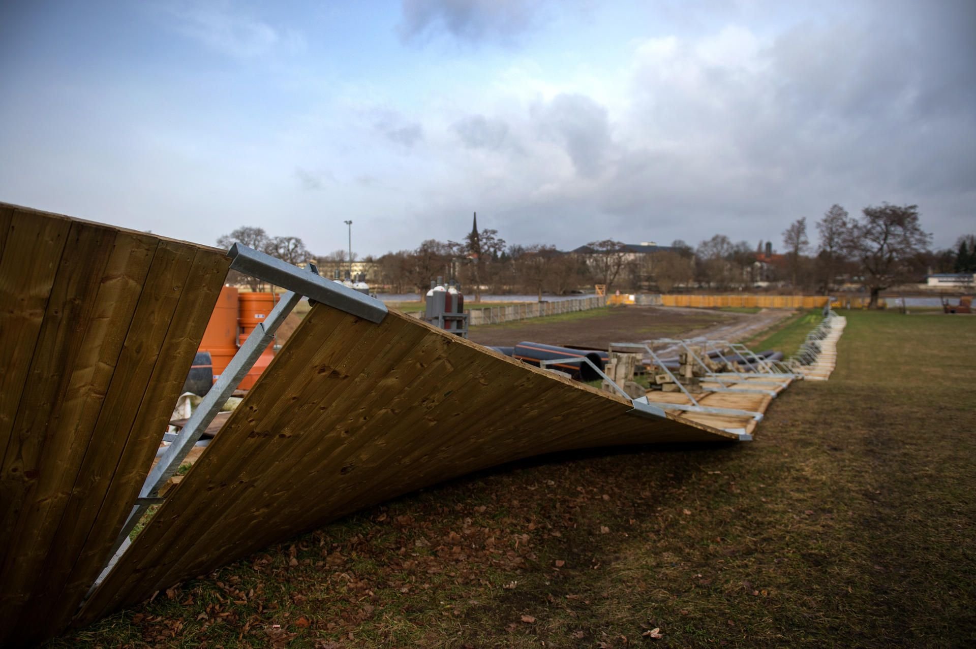 Ein hölzerner Bauzaun einer Baustelle am Fährgarten in Dresden liegt durch Starkwind umgekippt auf der Seite.