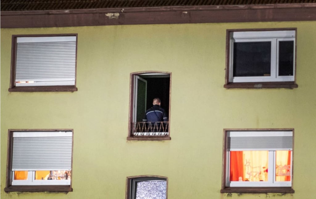Ein Polizist steht im Flur eines Mehrfamilienhauses, in dem zuvor Durchsuchungen stattgefunden haben. Im Dezember 2019 hatte die Polizei im Schrank eines Mannes aus Recklinghausen zufällig einen zweieinhalb Jahre lang vermissten Jungen entdeckt.