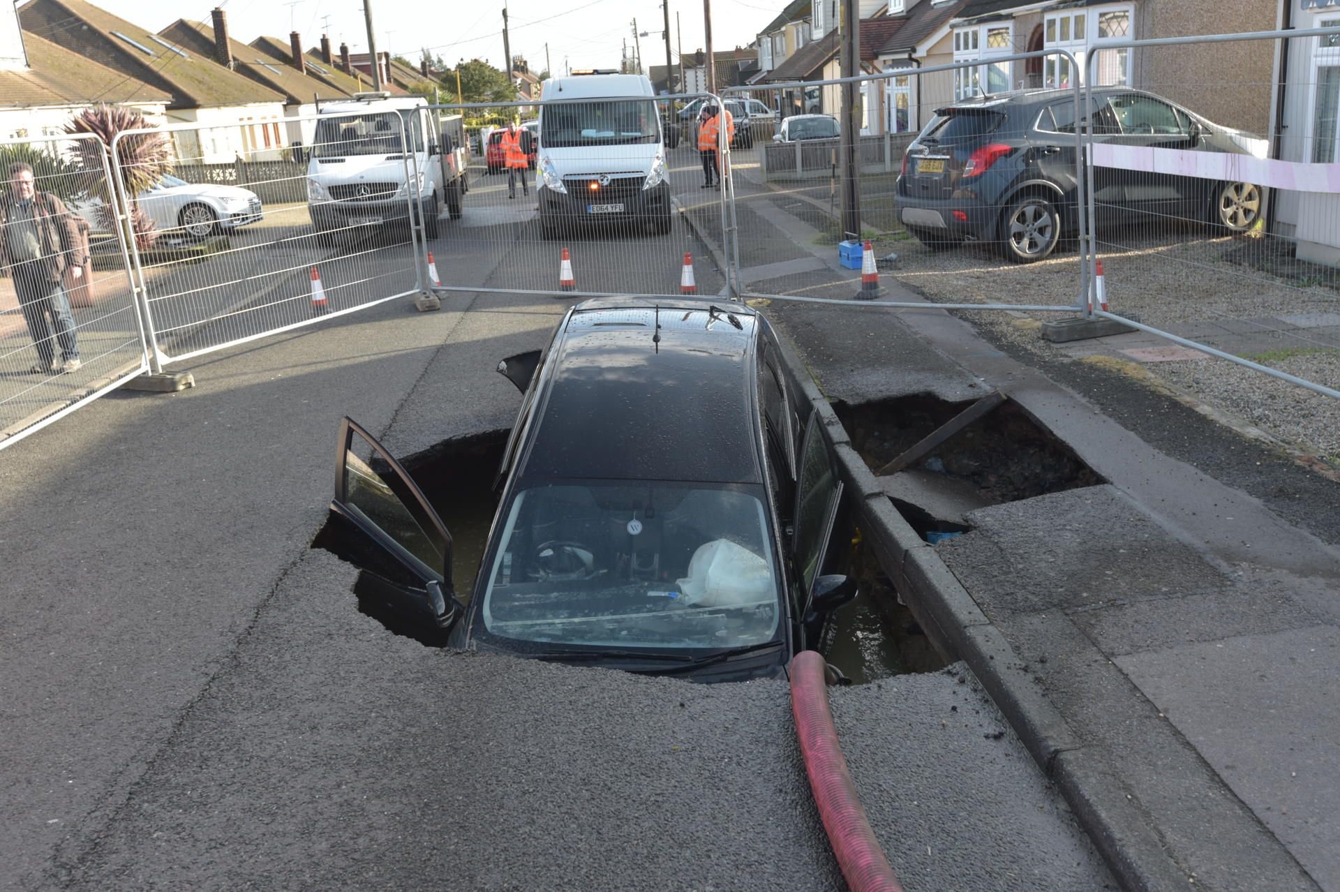 Ein Auto ist in einen kleinen Krater gestürzt, der über Nacht auf der Straße entstanden ist.