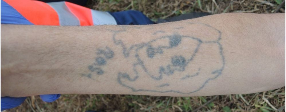 Auf dem Unterarm hat der Mann ein Tattoo. Unter dem Frauenkopf steht der Name „Rosi“.