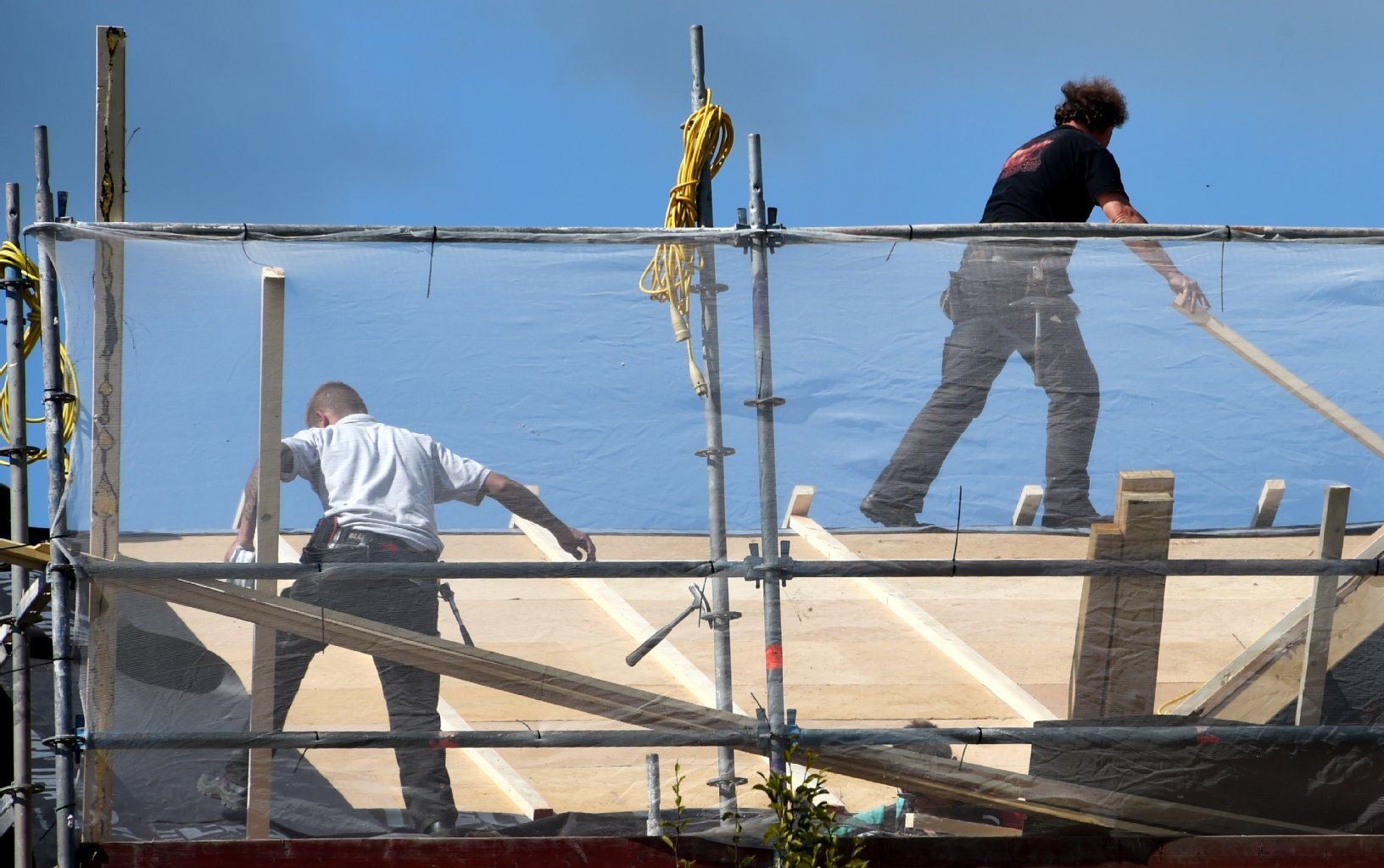 Handwerker arbeiten an einem Gebäude: Die meisten Handwerker in Deutschland machen trotz der weltweiten Konjunkturschwäche gute Geschäfte.