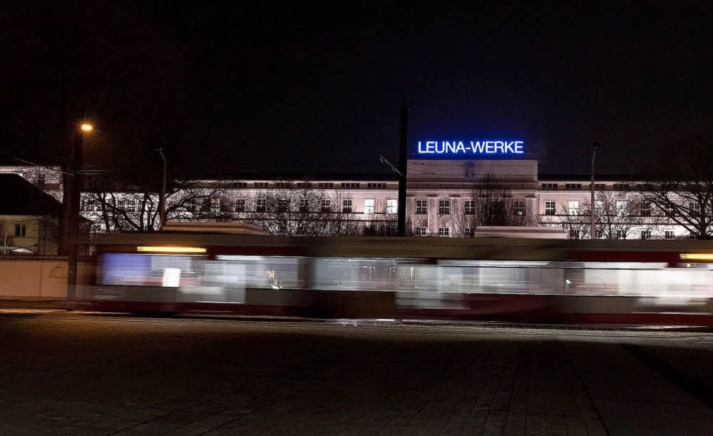 Eine Straßenbahn der Linie 5 fährt am Haupteingang zum Chemiepark in Leuna vorbei.
