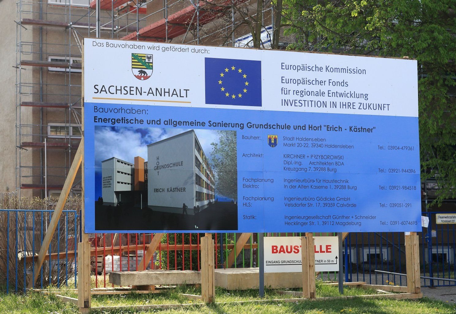Eine Informationstafel zum Bauvorhaben der energetischen und allgemeinen Sanierung der Erich-Kästner Grundschule und Hort steht in Haldensleben vor der Baustelle.
