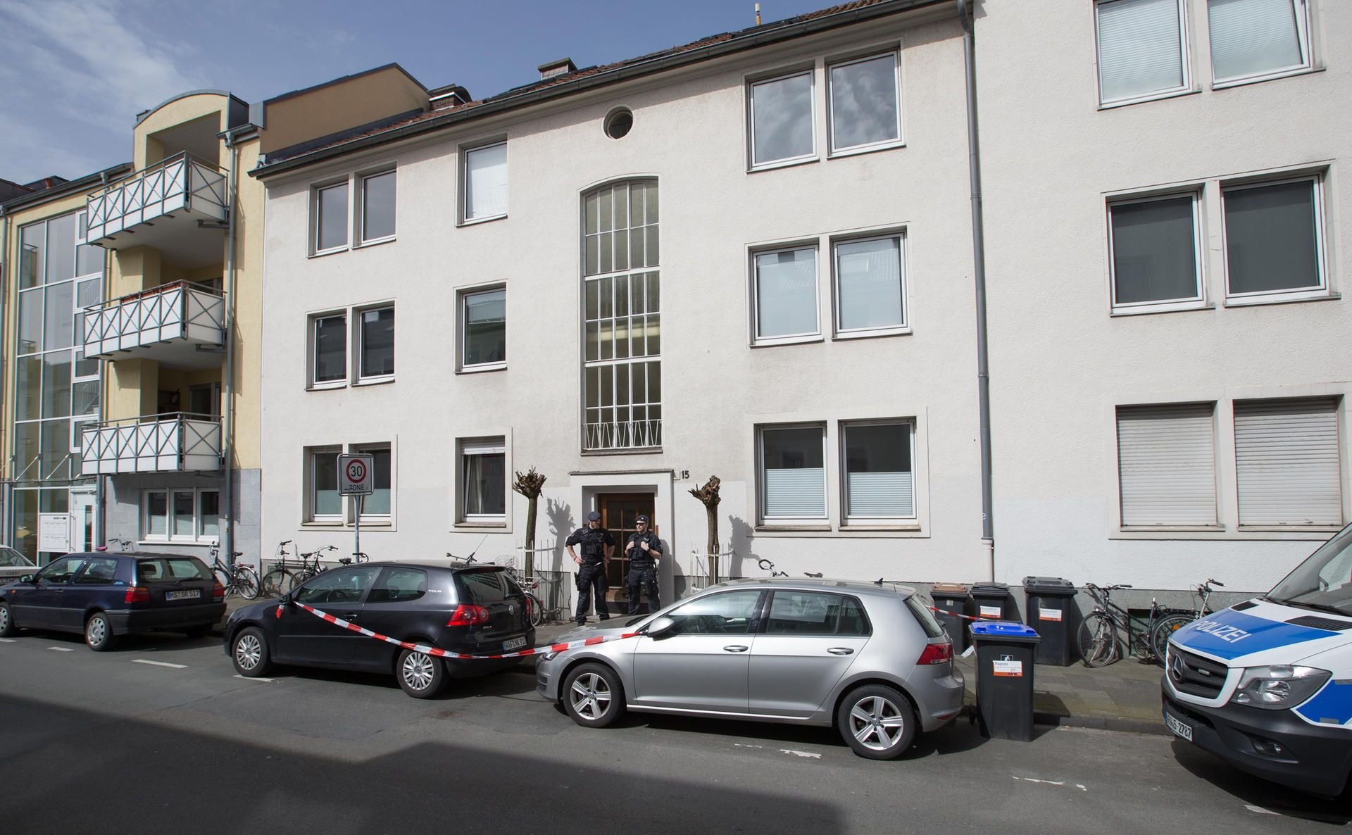 Polizisten stehen vor dem Haus mit der Wohnung des Amokfahrers.