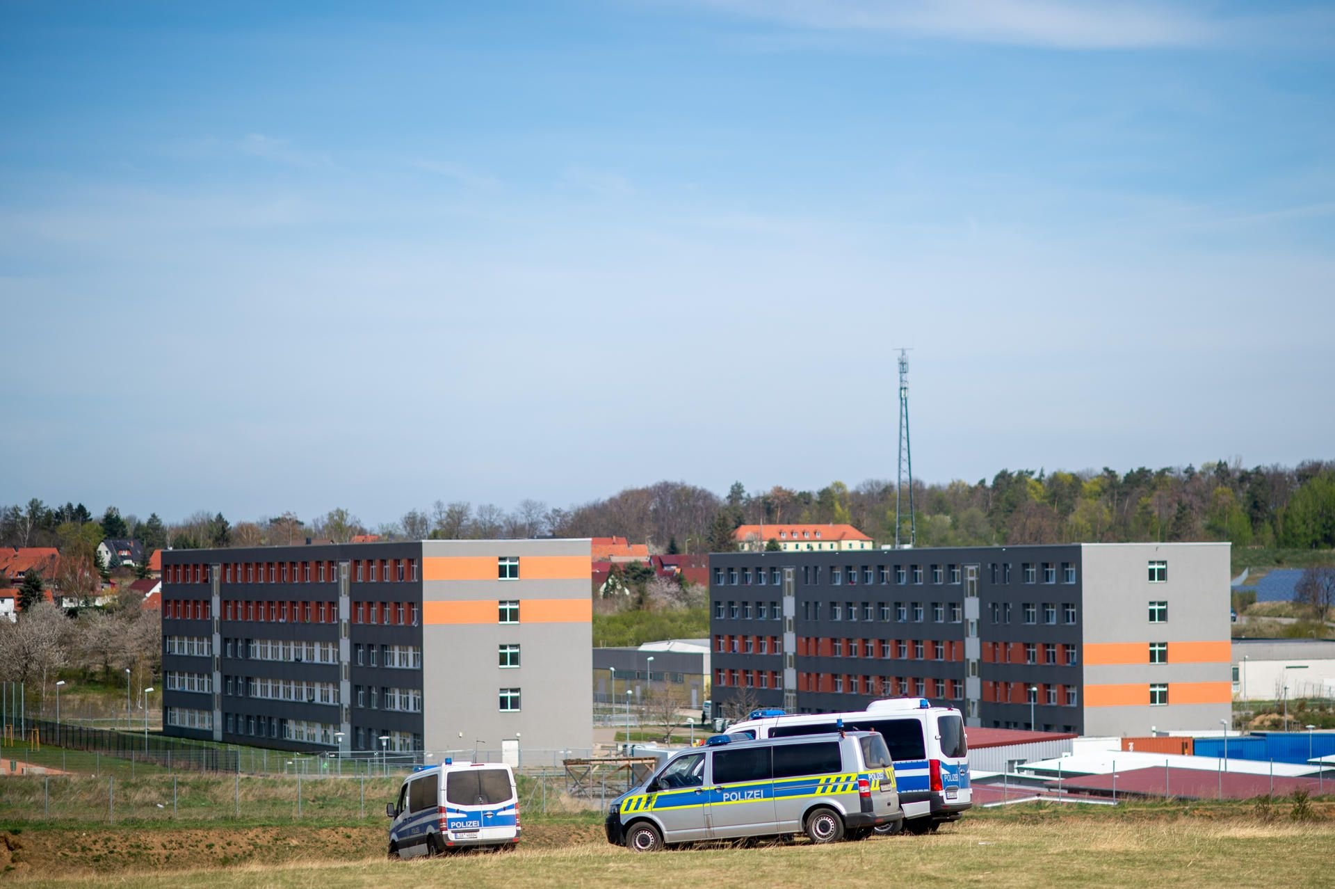 Polizeifahrzeuge stehen auf einer Anhöhe vor der Zentralen Anlaufstelle für Asylbewerber (Zast) in Halberstadt.
