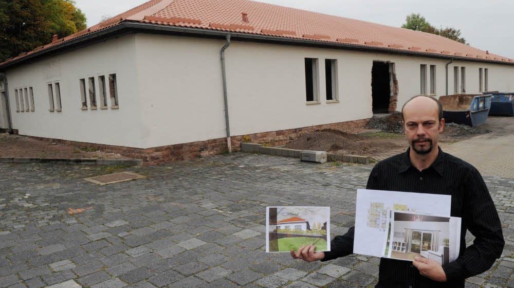 Vermieter Ronny Wagner mit den Plänen der Wohnanlage in der Hand vor der ehemaligen Kegelhalle