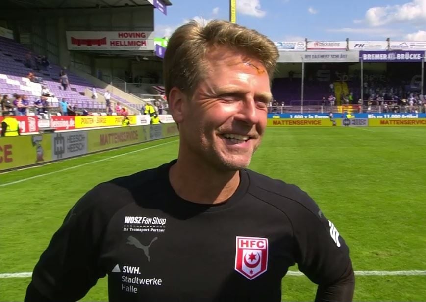 Gut gelaunt trotz Cut auf der Stirn: HFC-Trainer Rico Schmitt beim Interview mit Telekom Sport nach dem Spiel in Osnabrück.