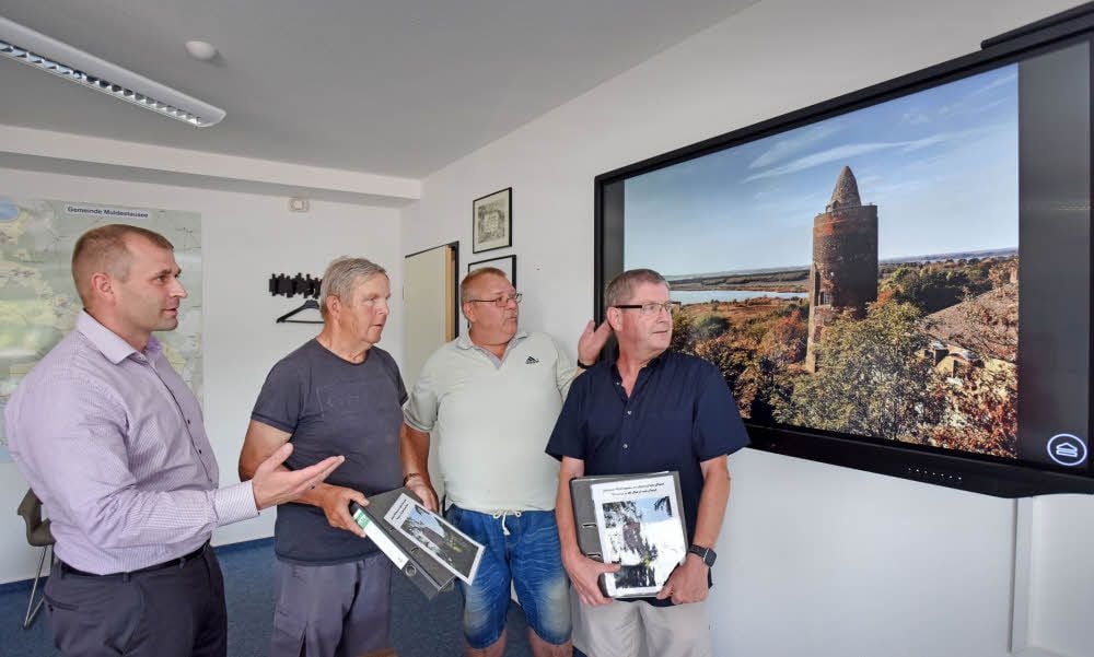 Bürgermeister Ferid Giebler mit den Turmwächtern Adolf Rebhahn, Karsten Leuchte und Rainer Baldofski vor dem Bild des Burgfrieds.