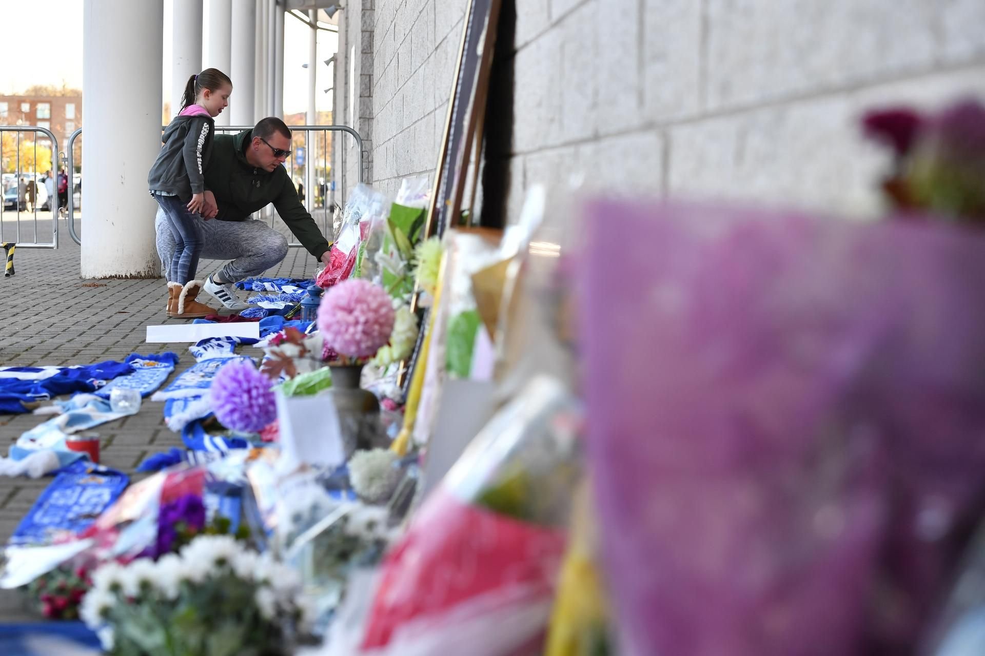 Ein Mann und ein Mädchen legen Blumen zum Gedenken der Opfer am Leicester-Stadion nieder.