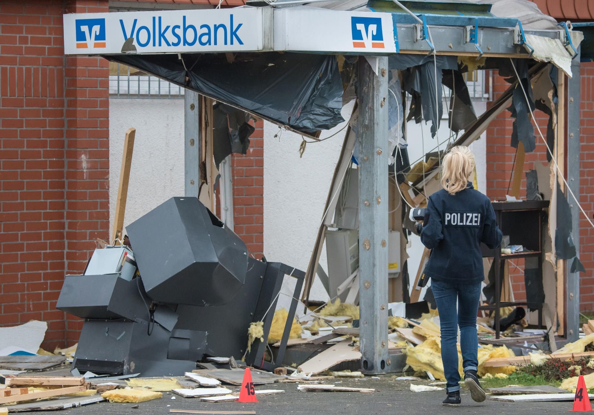 Eine Polizistin steht vor einem gesprengten Geldautomaten. Die Sprengung von insgesamt vier Geldautomaten in Niedersachsen und Sachsen-Anhalt wird einem 45-Jährigen vorgeworfen.