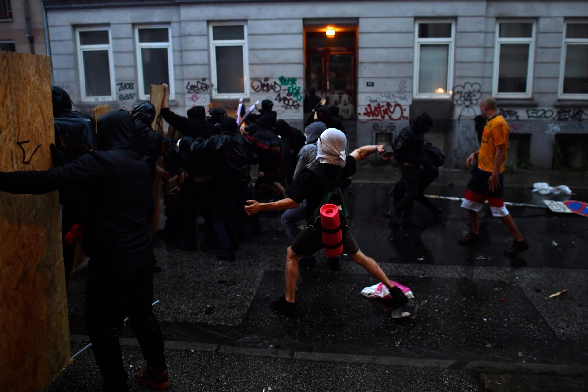 Ein gewalttätiger Demonstrant wirft in Hamburg bei Protesten gegen den G20-Gipfel einen Stein in Richtung von Polizisten.