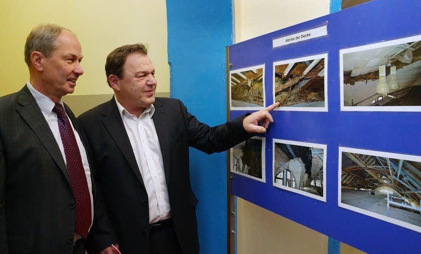 Michael Wölfer (r.) und Eberhard Brecht lassen anhand vieler Fotos die Sanierungsarbeiten an der Decke des Stadtbades Revue passieren.