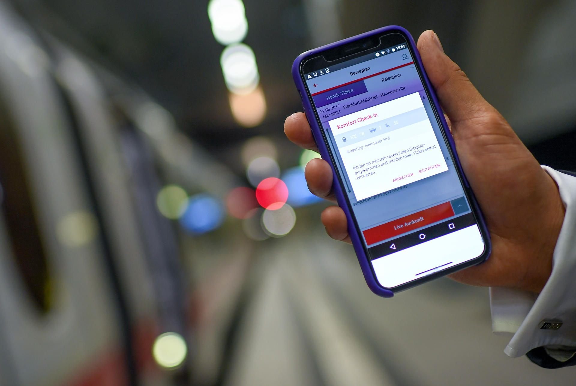 Ein Fahrgast nutzt die App der Deutschen Bahn „DB Navigator“ für den digitalen Check-in.