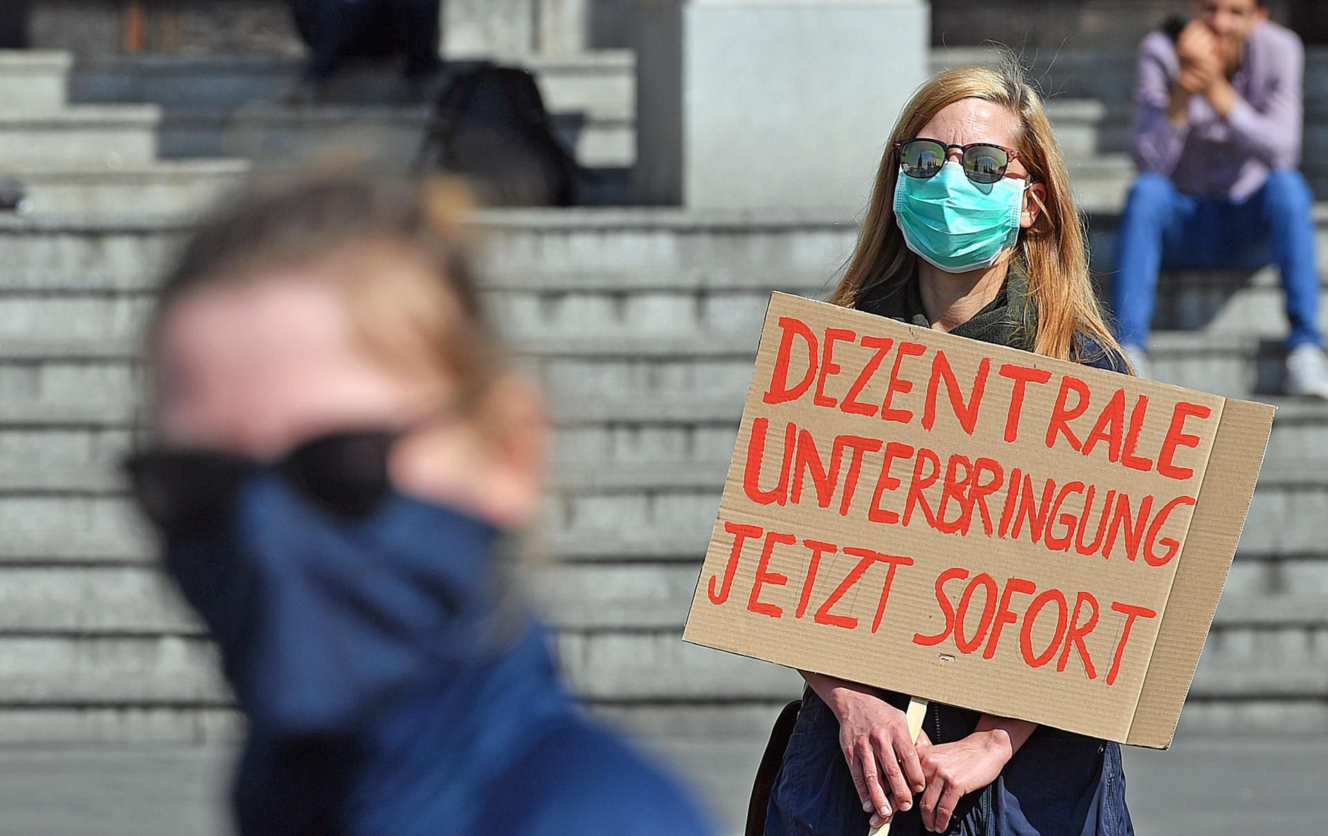 Mit Mundschutz und Sicherheitsabstand halten rund 50 Menschen auf dem Markt in Halle eine Kundgebung ab. Eine Forderung ist die Schließung der zentralen Erstaufnahme für Geflüchtete in Halberstadt.