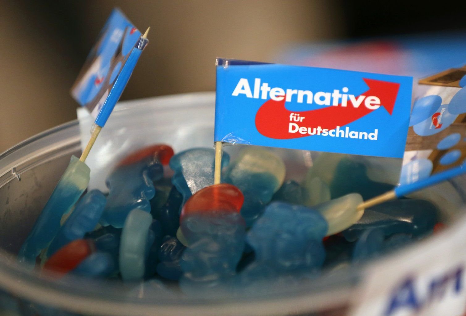Fähnchen der AfD stehen in einer Schale Süßigkeiten.