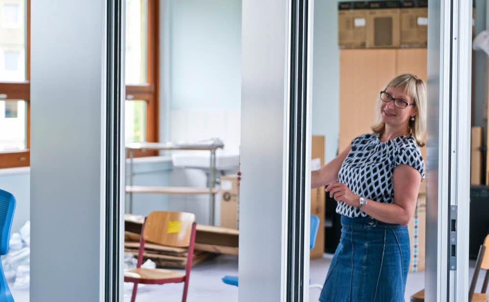 Schulleiterin Romina Altenburg öffnet die neuen Trennwände im Musikklassenzimmer der Marguerite Friedlaender Schule.