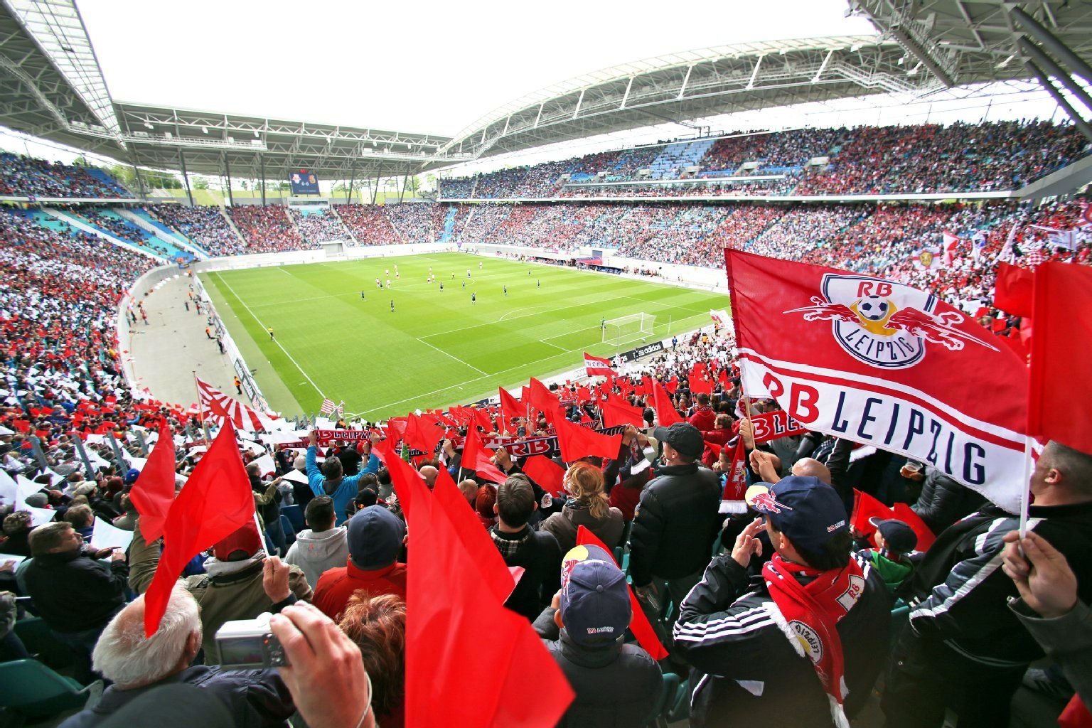 Fans von RB Leipzig feuern in der Red-Bull-Arena in Leipzig ihre Mannschaft an.