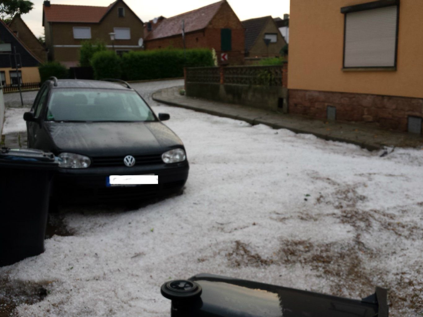 Ein weißer Teppich aus Hagelkörnern bedeckt nach dem Gewittersturm am Dienstagabend eine Straße im Eisleber Ortsteil Rothenschirmbach.
