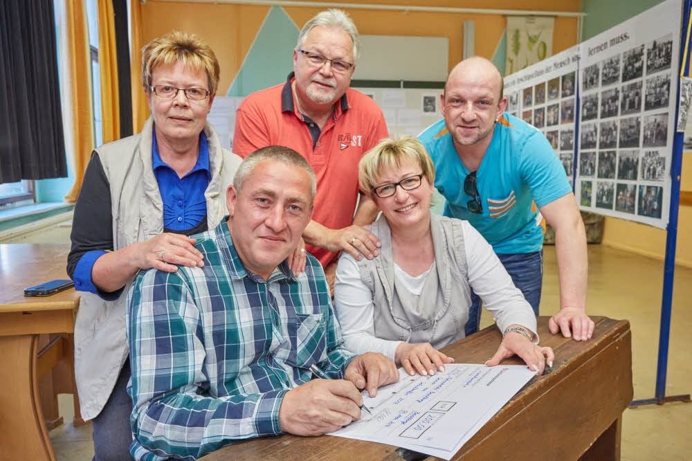 Unter strenger Aufsicht unterschreibt Heiko Scharf (vorn links) die Schecks für Hort und Kindergarten.