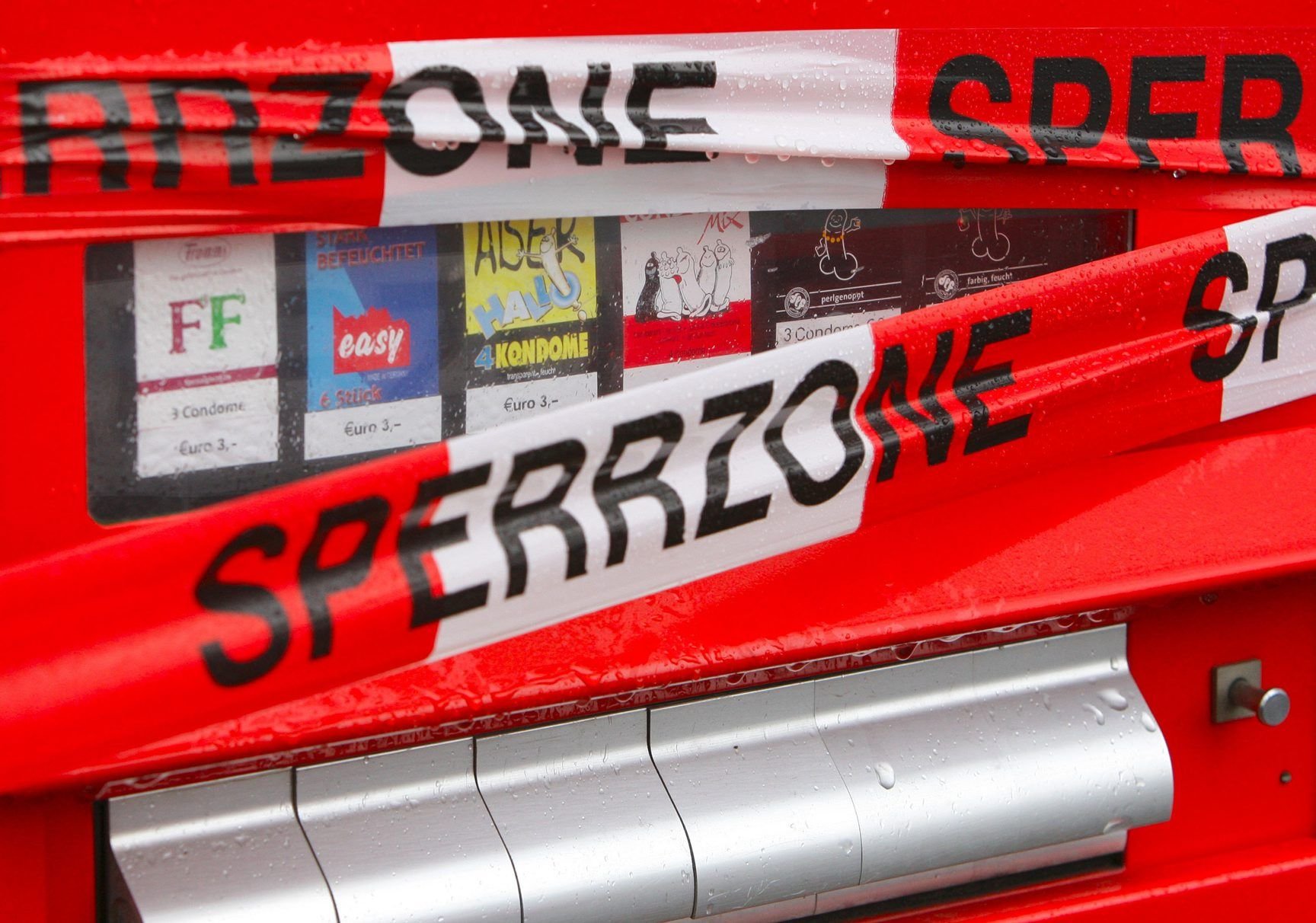 Ein Kondomautomat ist mit Absperrband der Polizei umwickelt.