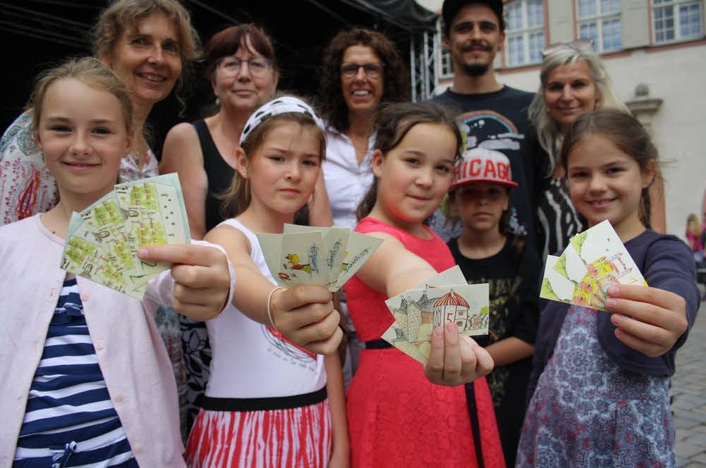 Pia aus der Klasse 2a, Hannah aus der 2b, Marie aus der vierten Klasse und Marlen aus der 3b der Kleersgrundschule präsentieren - gemeinsam mit Organisatoren und Ausrichtern der Kinderstadt - die von ihnen entworfenen Kaiserlinge.