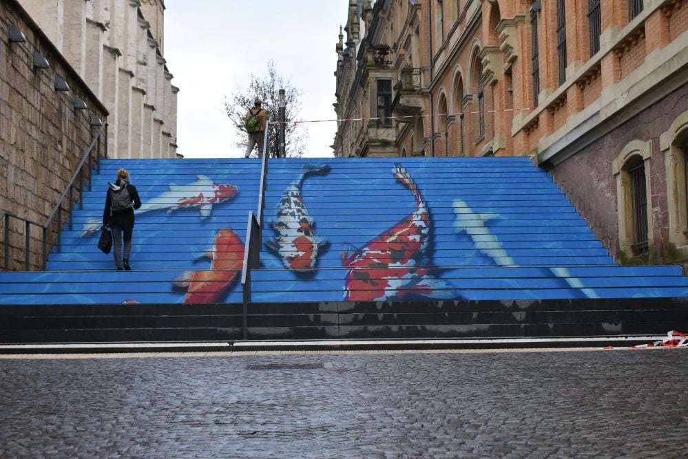 Halles Fischtreppe: Zwischen Hallmarkt und Markt schwimmen dank eines Street-Art-Projekts der EVH bunte Kois auf blauem Grund.
