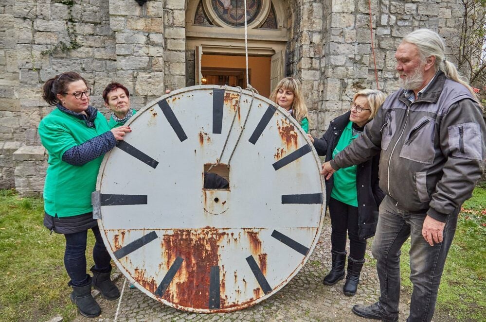 Ivonne Gutzeit, Edith Hoffmann, Simone Schubert und Karola Schulz (von links) aus der Kirchengemeinde Peißen freuen sich, dass die Ziffernblätter endlich restauriert werden. Diesen Job übernimmt Uhrmacher Helmut Ebert (rechts).