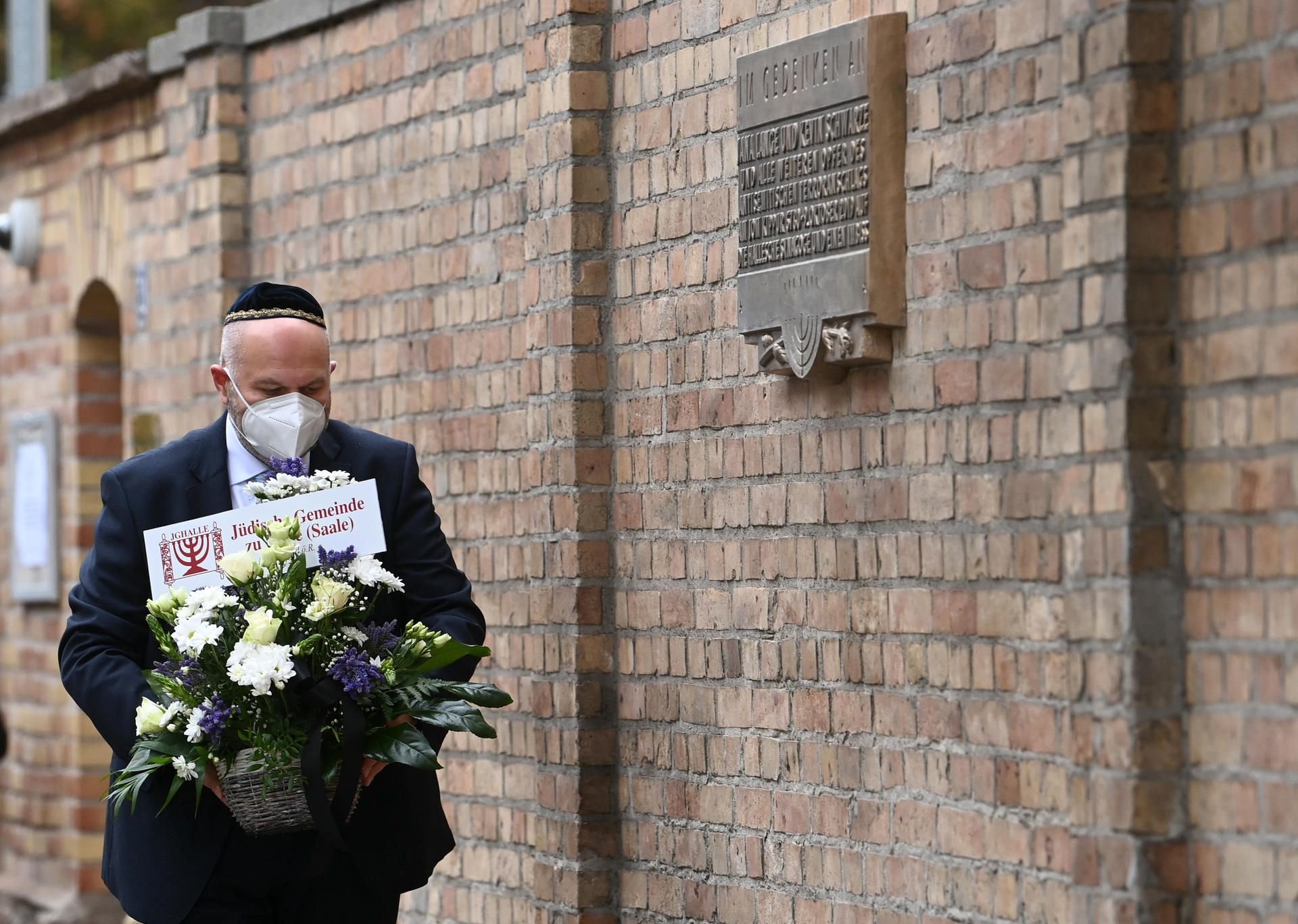 Max Privorozki, Vorsitzender der Jüdischen Gemeinde Halle, legt Blumen an der neuen Gedenktafel für die Opfer des Anschlages nieder.