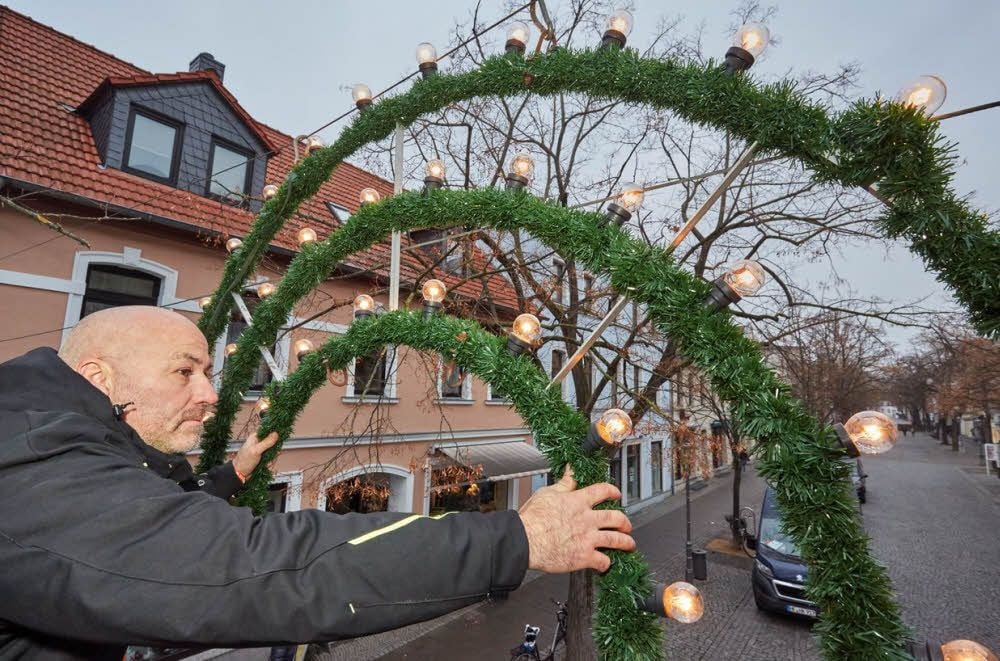 Mirko Raßler befestigt die Adventsbeleuchtung über dem Bernburger Boulevard. Am nächsten Donnerstag wird sie eingeschaltet. Dann kann auf dem Heele-Christ-Markt schon der erste Glühwein verkostet werden.