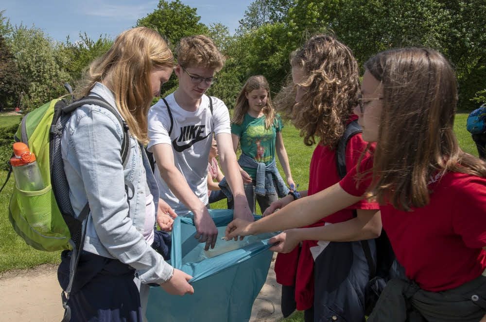 Schüler sammeln am Freitag im Wordgarten in Quedlinburg Müll.