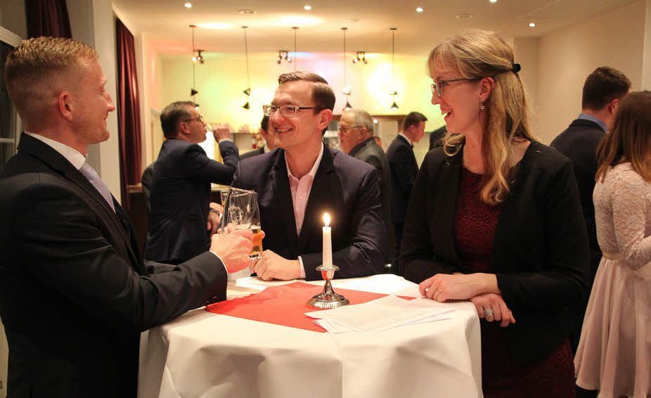 Die Gäste unterhalten sich in lockerer Runde an einem der Stehtische.